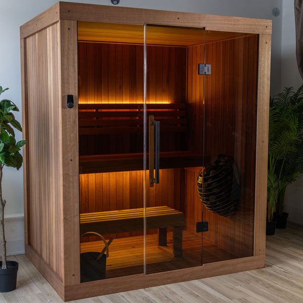 Corner view of wood sauna with glass front, bench seating, and heater on right