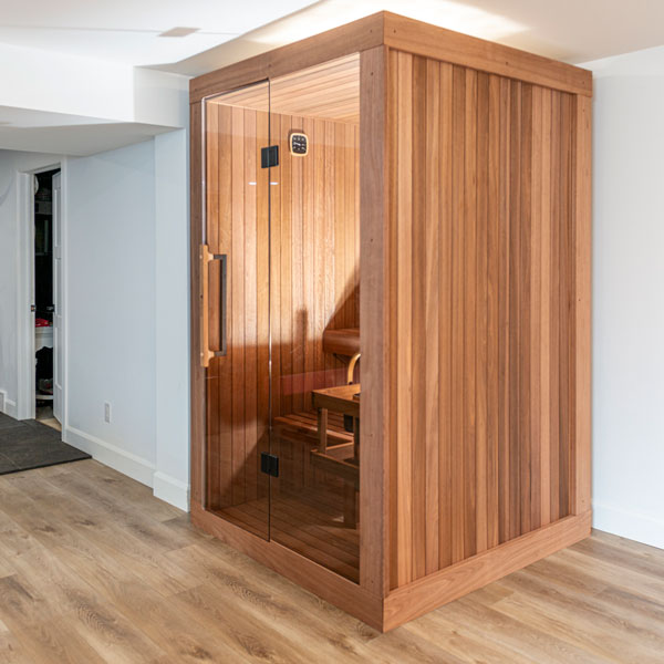 Wooden corner sauna with open glass door and built-in bench seating inside