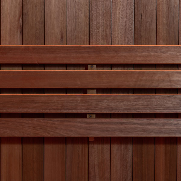 Close-up of wooden sauna bench slats and wall panels with built-in heater supports.