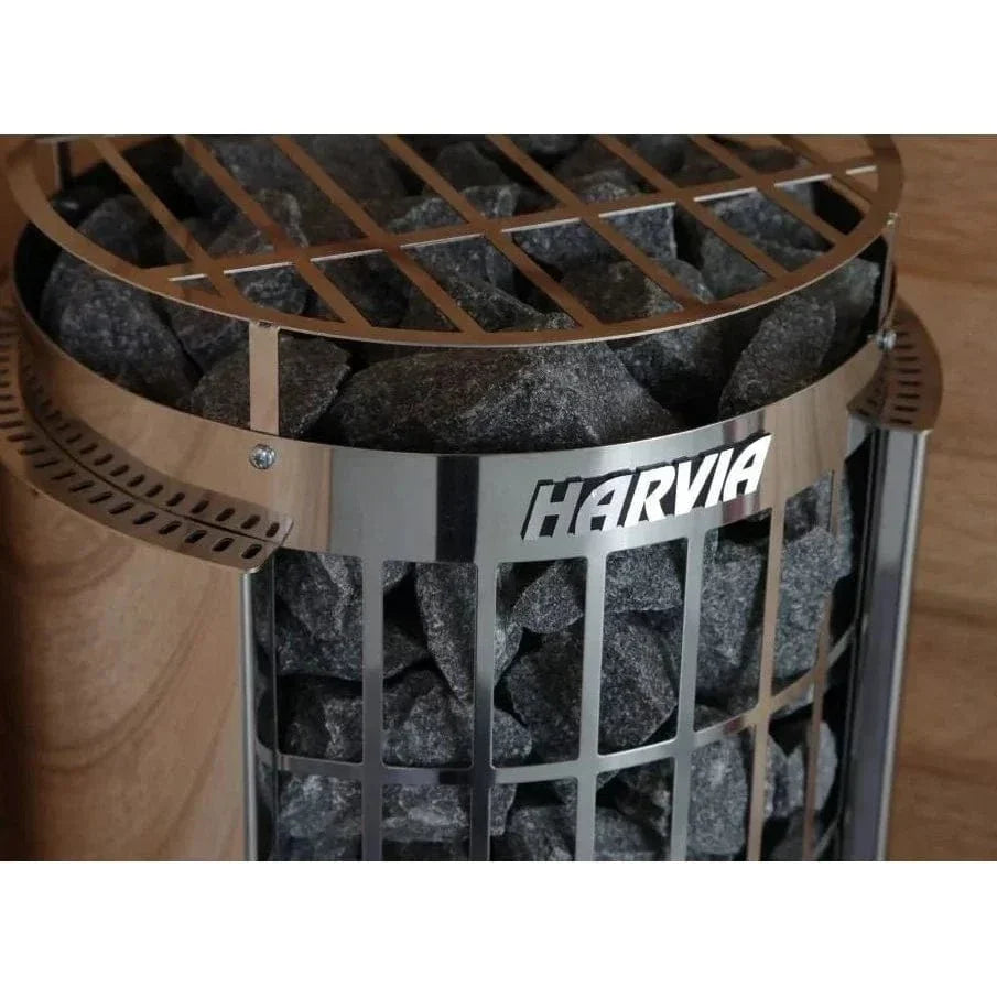Close-up of stainless sauna heater top rim with HARVIA label and dark stones