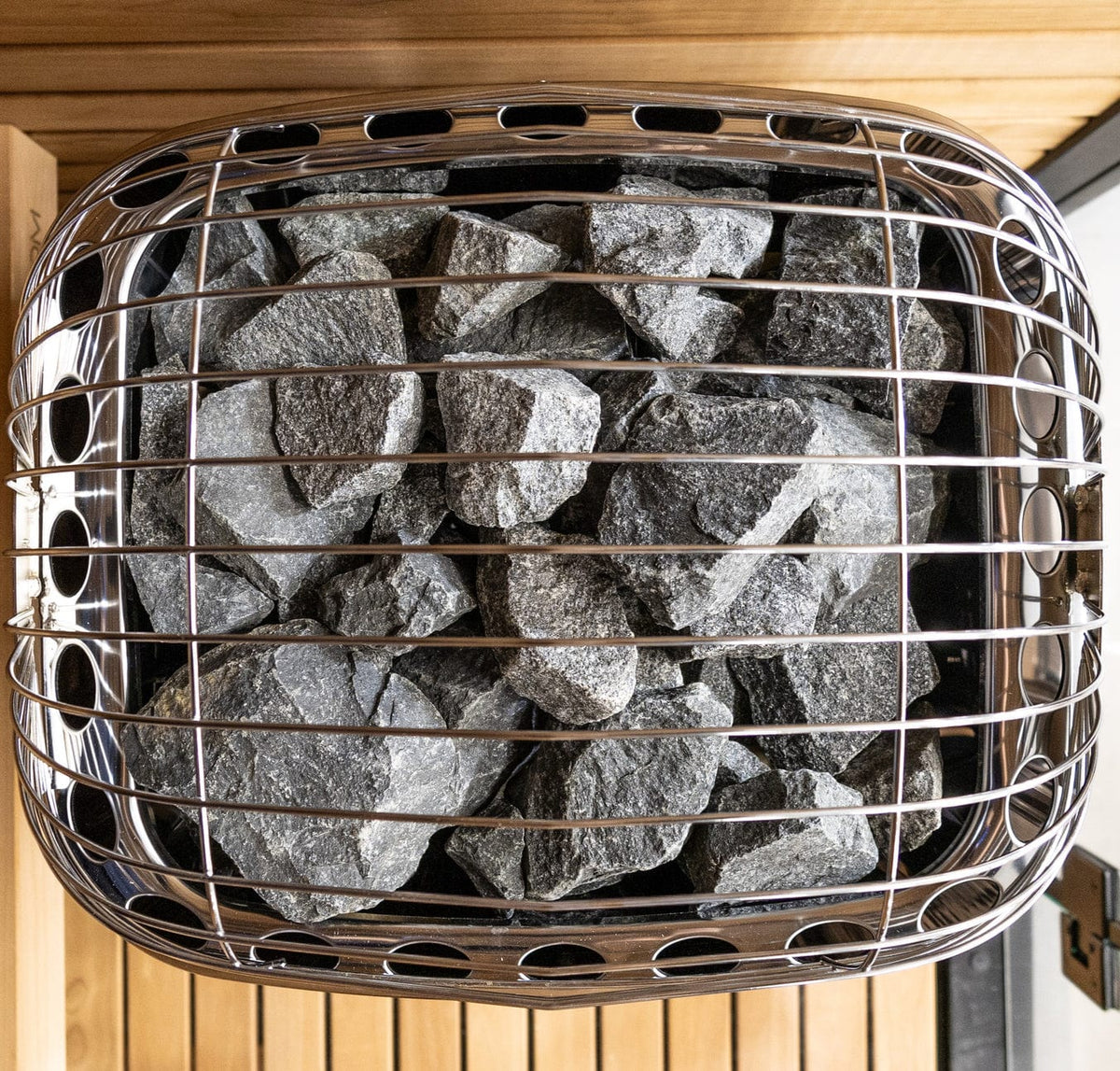 Harvia sauna heater basket filled with gray stones and metal protective cage