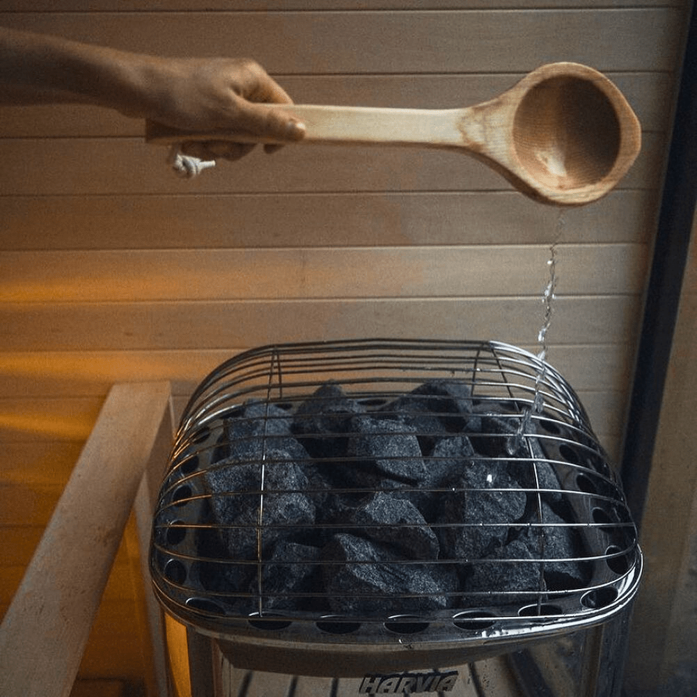 Harvia sauna heater with stone-filled wire guard and gray stones