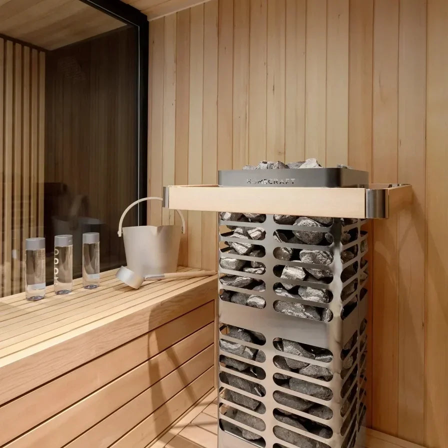 Electric sauna heater with rocks behind a stainless guard in a wooden sauna