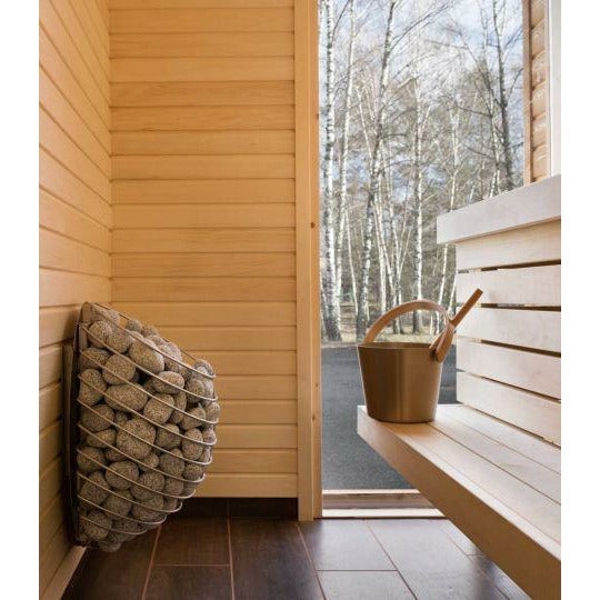 Outdoor view of a stone-filled sauna heater beside a wooden sauna