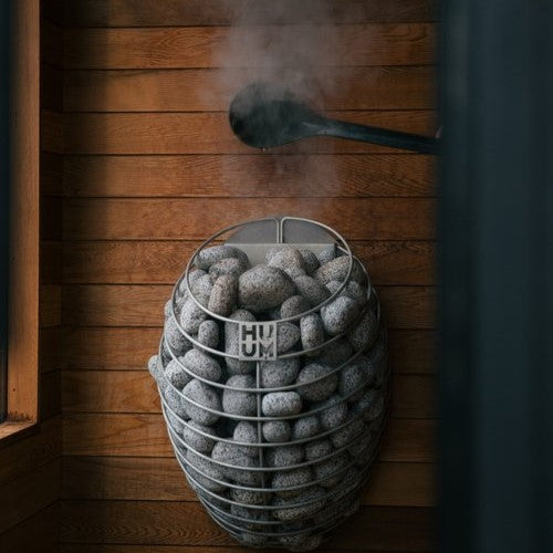 Electric sauna heater basket with gray sauna stones