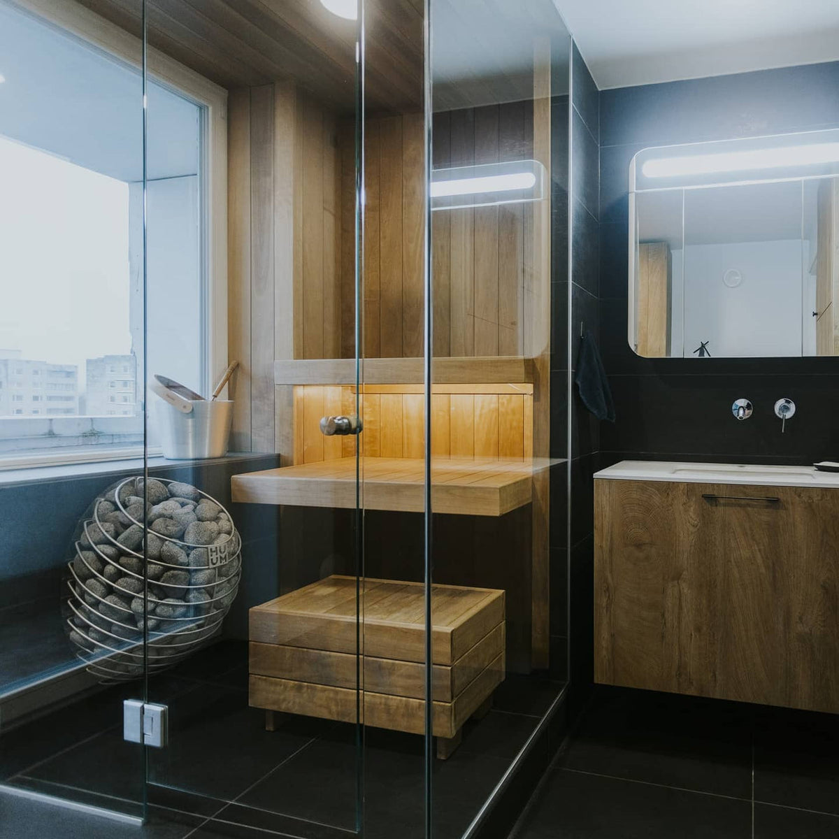 Sauna heater with stacked grey stones in a wooden sauna interior