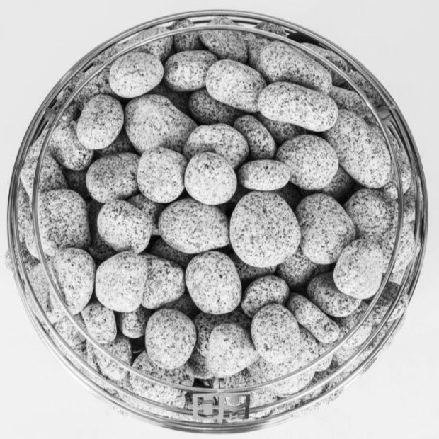 Light gray sauna rocks in a round metal tray close-up