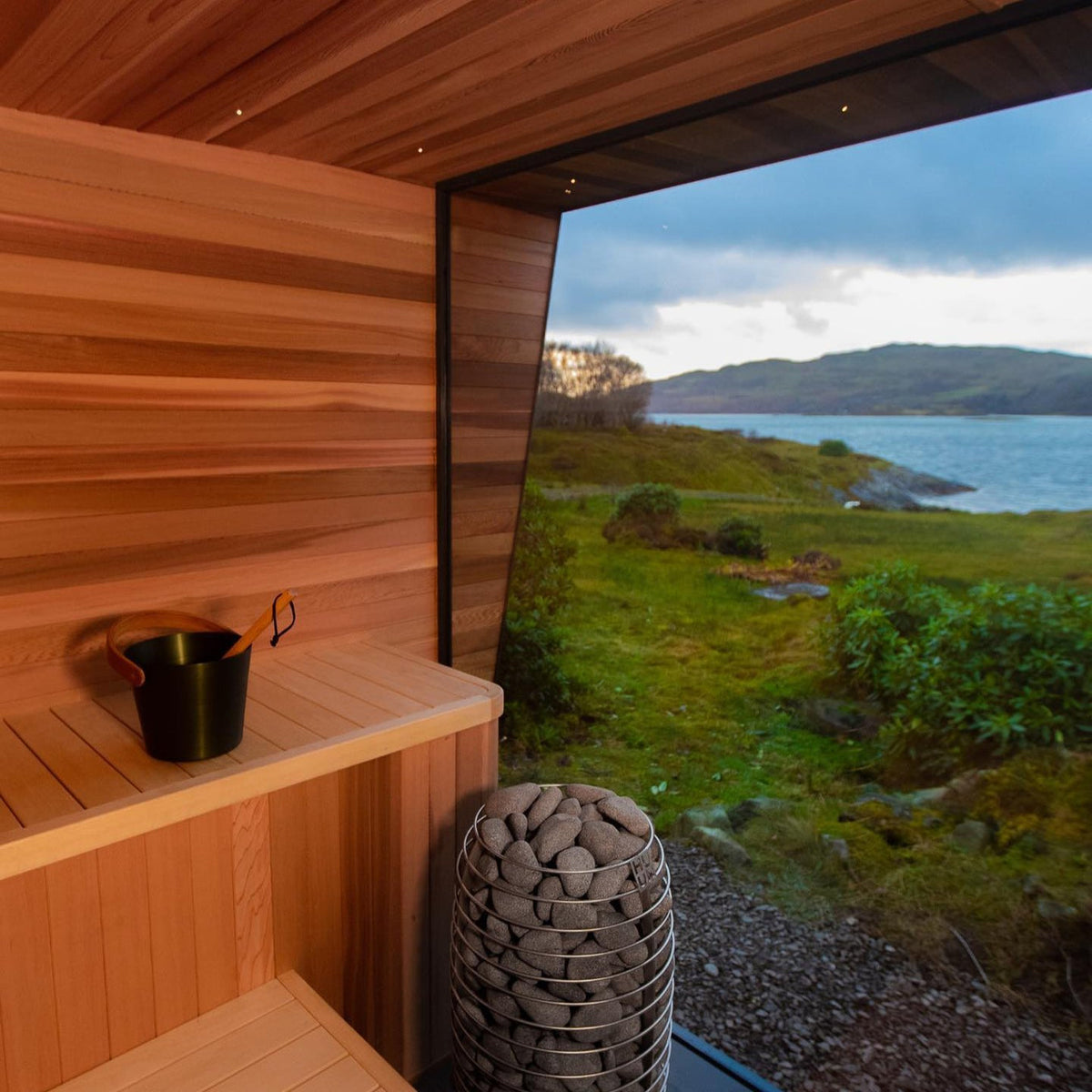 Outdoor electric sauna heater with stacked gray stones on a circular base