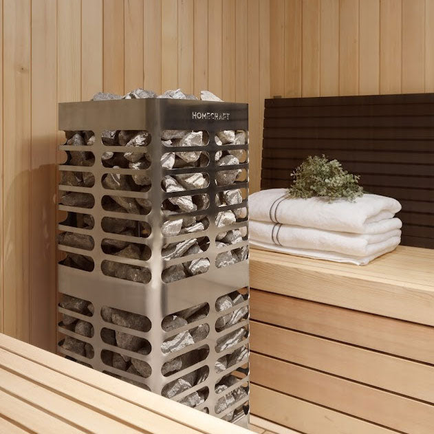 Homecraft electric sauna heater with visible stones and stacked towels in a sauna