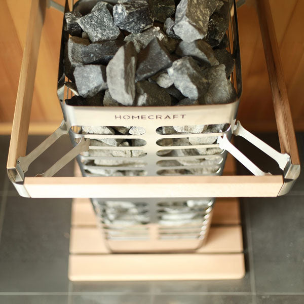 Electric sauna heater with metal rock tray holding gray sauna stones