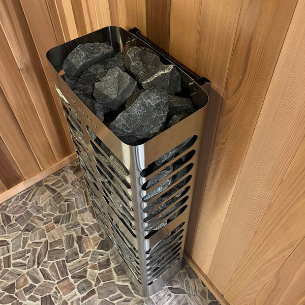 Tall stainless electric sauna heater with gray stones, side vent pattern, and open top