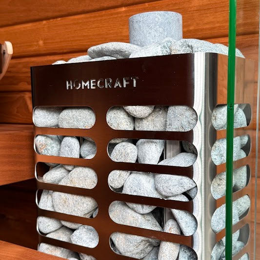 HOMECRAFT sauna heater close-up with white-gray stones behind dark metal grille slats