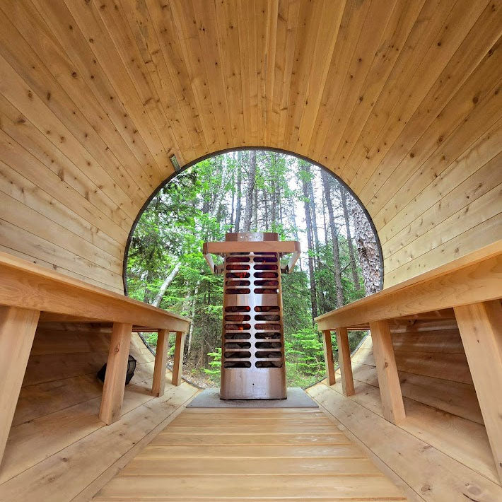 Freestanding electric sauna heater with red heating elements in wooden sauna