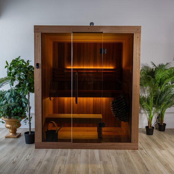 Wood-paneled sauna with glass door, benches, and glowing light inside