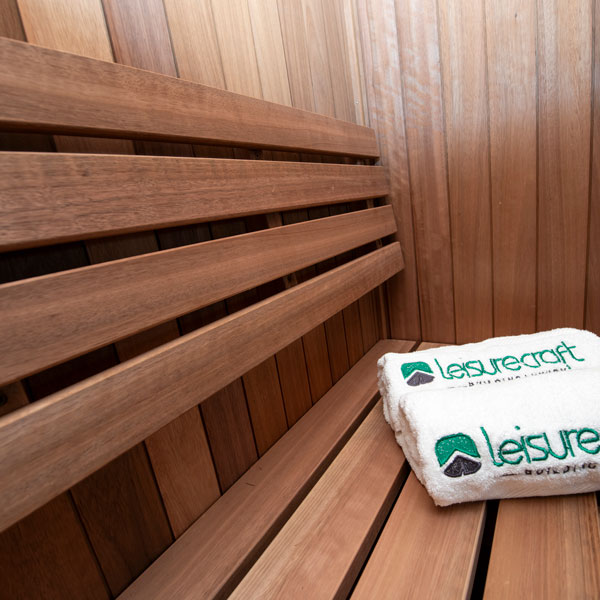 Wooden sauna bench slats with folded towel resting on the seating surface