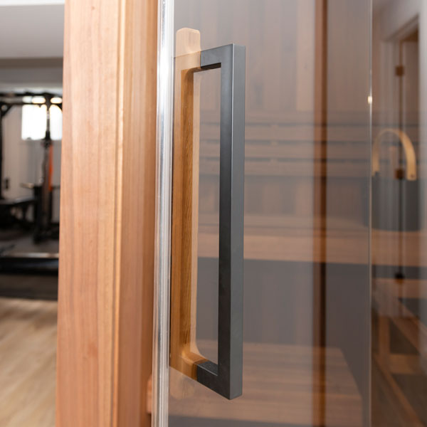 Close-up of sauna glass door handle and clear glass panel