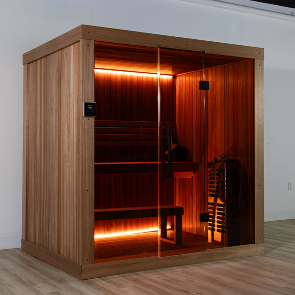 Wooden studio sauna with glass door, built-in heater, and tiered bench seating.