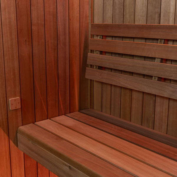 Wooden sauna bench corner with horizontal slats and vertical wall paneling.