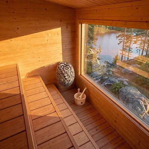 Wood sauna interior with benches, window, and stone heater by side wall