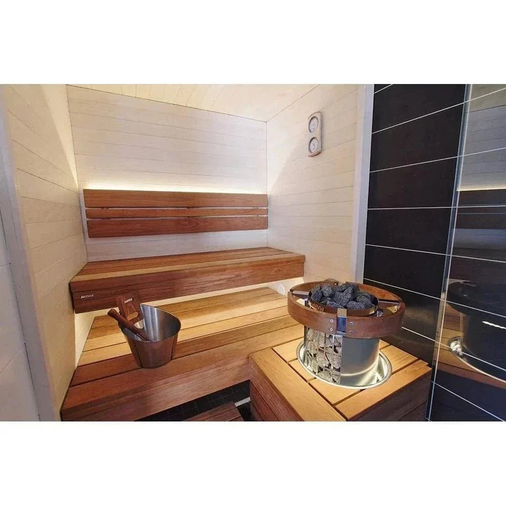 Sauna interior featuring a compact stone sauna heater with stainless steel casing