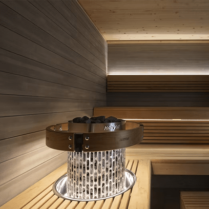 Sauna heater with stainless steel body and stone top opening in sauna bench area