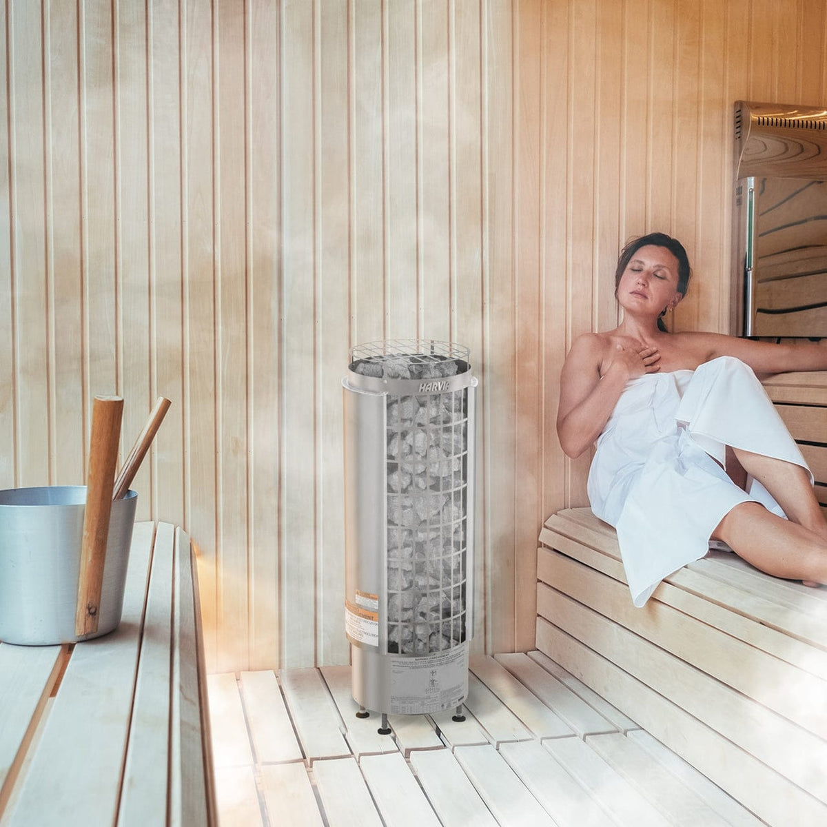 Cylindrical sauna heater with stone basket and lower control unit base