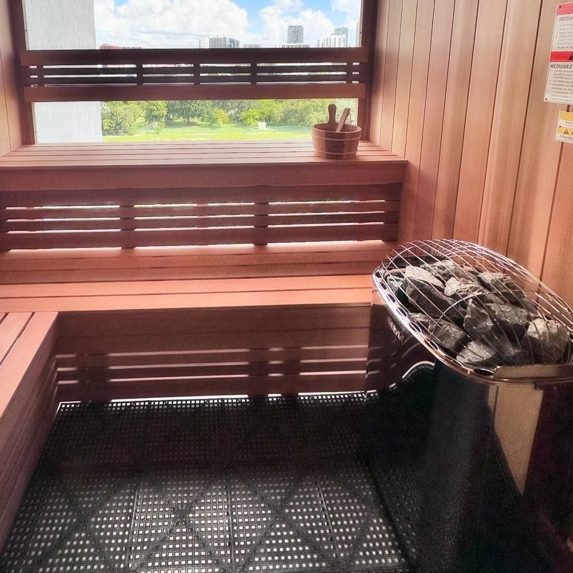 Sauna heater with covered stone barrel inside a wooden sauna with bench seating
