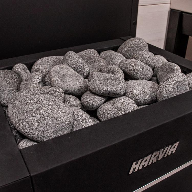 Harvia electric sauna heater stones in black compartment, gray rocks