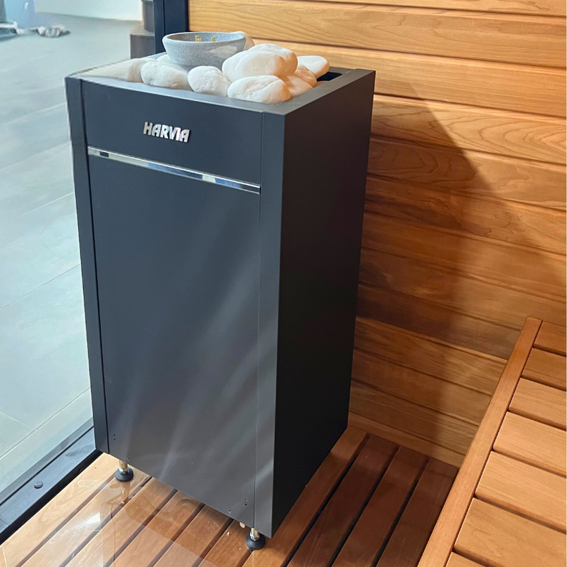 Electric sauna heater with stone top and folded light-colored sauna stones