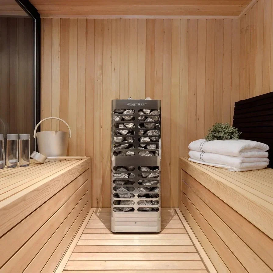 Homecraft electric sauna heater in a wooden sauna room beside stacked towels