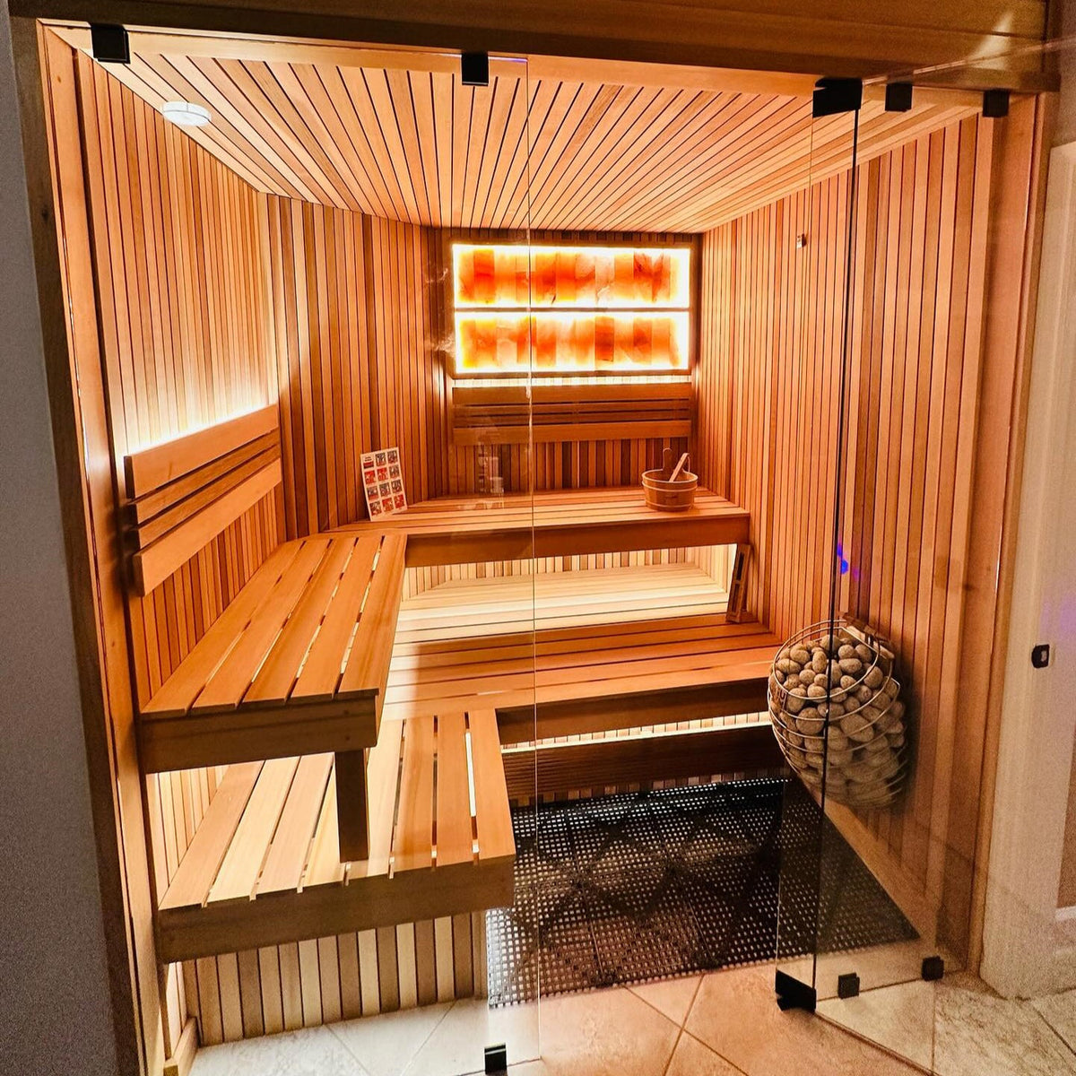 HUUM electric sauna heater with gray stones in a metal ring basket