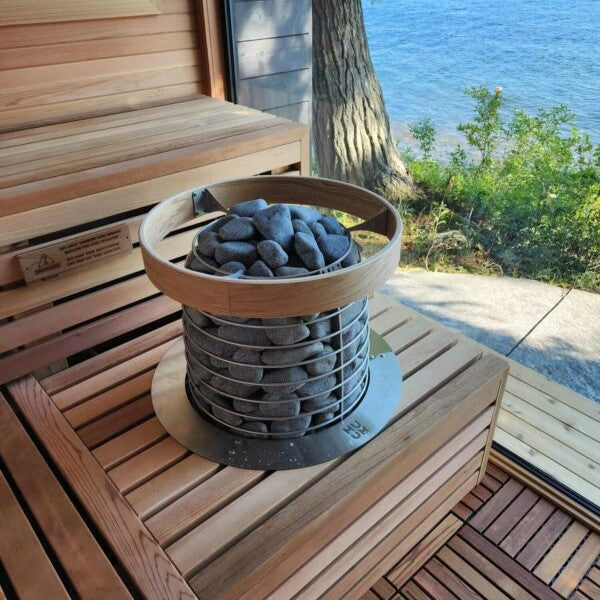 Stone heater basket on sauna bench near window opening
