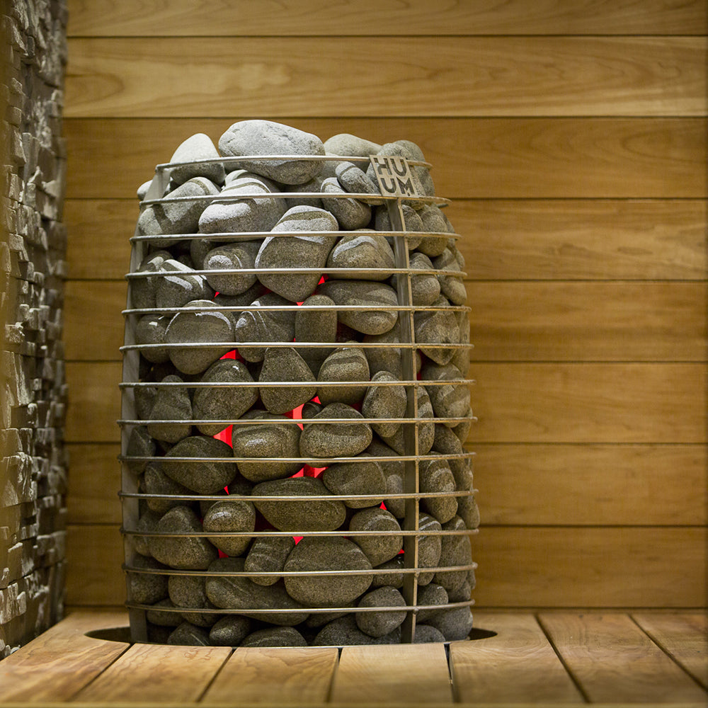Sauna heater stones packed tightly in a metal cage with HUUM branding on top