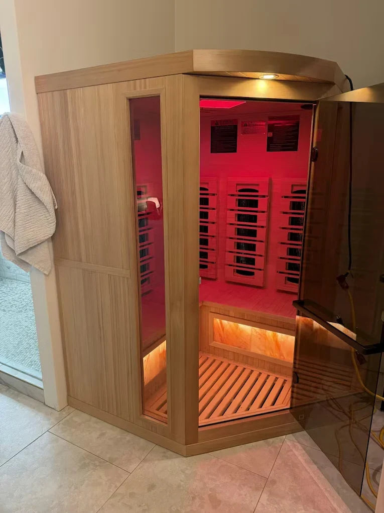 Corner infrared sauna with wood frame and red-lit bench interior